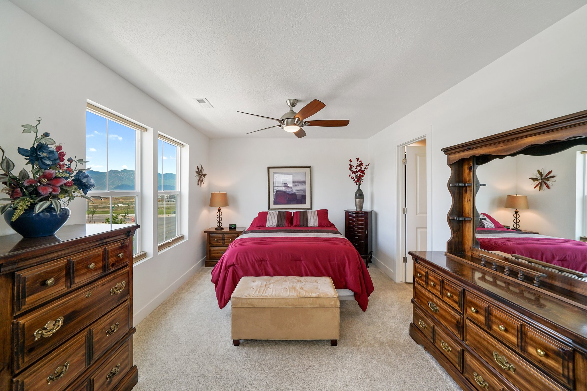 Bedroom with light colored carpet, a mountain view, ceiling fan, and a textured ceiling