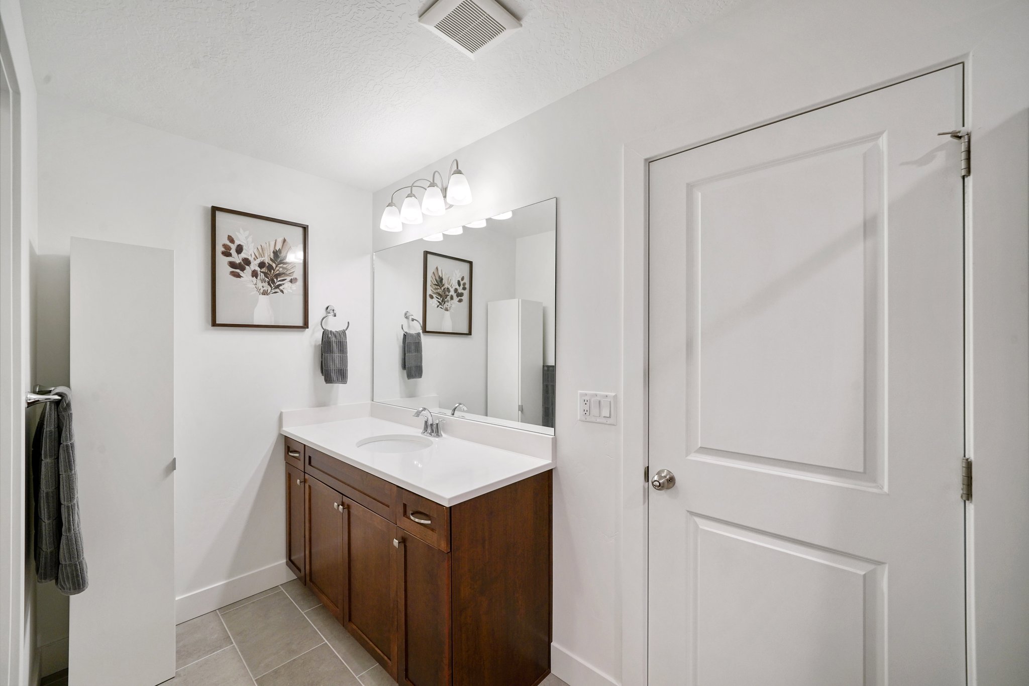 Bathroom featuring vanity, light tile patterned floors, and a textured ceiling