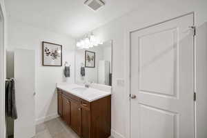 Bathroom featuring vanity, light tile patterned floors, and a textured ceiling