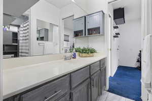 Full bathroom with vanity, light carpet, and curtained shower