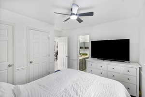 Bedroom with multiple closets, ceiling fan, and ensuite bathroom
