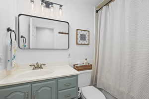Bathroom featuring vanity and shower / bath combination with curtain