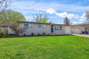 View of front of property featuring brick siding, driveway, and a garage