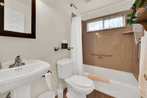Full bath featuring shower / bath combo and toilet