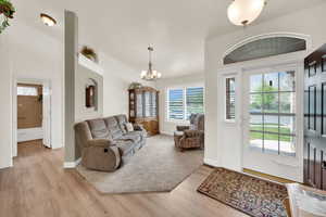 Living room featuring suspended lighting and light wood-type flooring