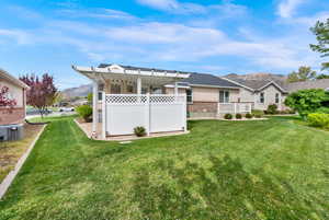 Rear view of property featuring a mountain view, a yard, and brick siding
