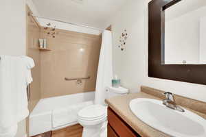 Full bath with vanity, shower / bath combination with curtain, and light wood-style flooring