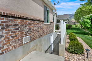 Entrance to property with brick siding, a mountain view, and stucco siding