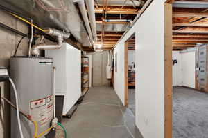 Unfinished basement featuring gas water heater and a central vacuum unit