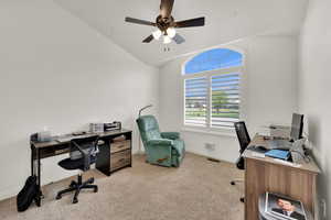 Office area featuring light colored carpet, vaulted ceiling, and a ceiling fan