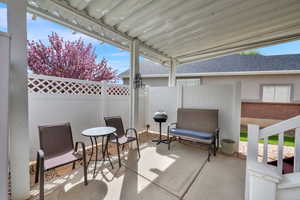 Fenced backyard featuring a patio area and grilling area