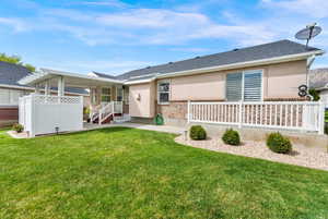 Back of property featuring a patio, stucco siding, brick siding, and a shingled roof