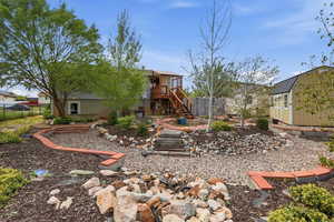 Rear view of property featuring a storage unit, a deck, and a residential view