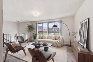 Living area with light colored carpet and a residential view