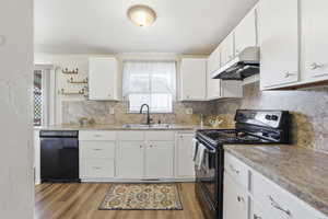 Kitchen featuring black appliances, white cabinets, light countertops, light wood-style flooring, and open shelves