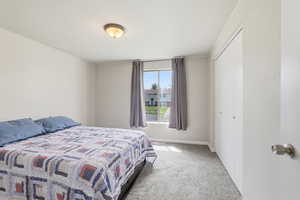 Bedroom with light carpet and a closet