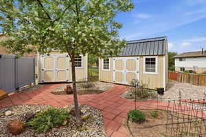 Fenced backyard featuring a storage unit