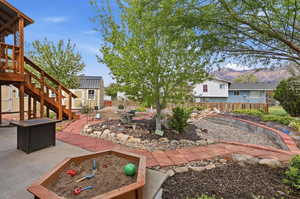 Fenced backyard with a patio area, a storage shed, a mountain view, and a garden