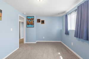 Spare room featuring light carpet and baseboards