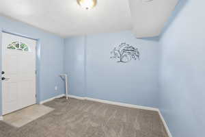 Entryway featuring a textured ceiling and carpet flooring