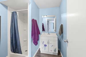 Full bath featuring a stall shower, vanity, dark wood-style flooring, and a textured ceiling