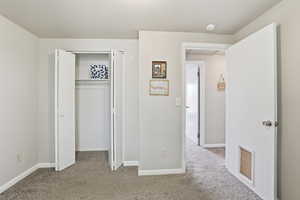 Unfurnished bedroom with light colored carpet and a closet