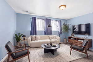 Carpeted living area featuring baseboards
