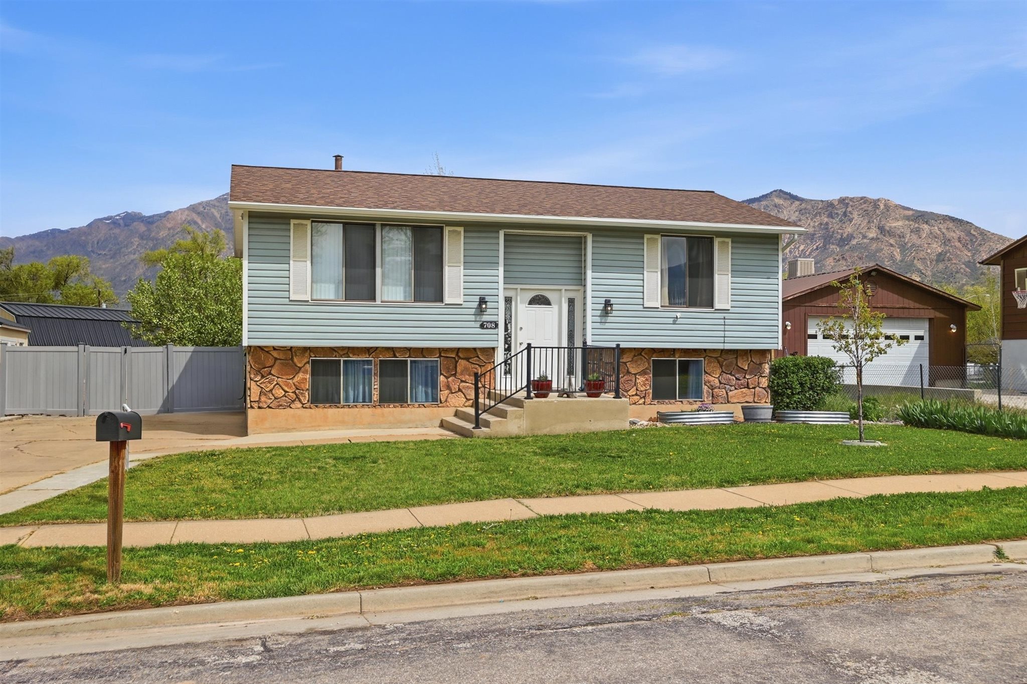 Split foyer home with a mountain view, stone siding, and a shingled roof