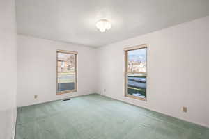 Spare room with light carpet and a textured ceiling