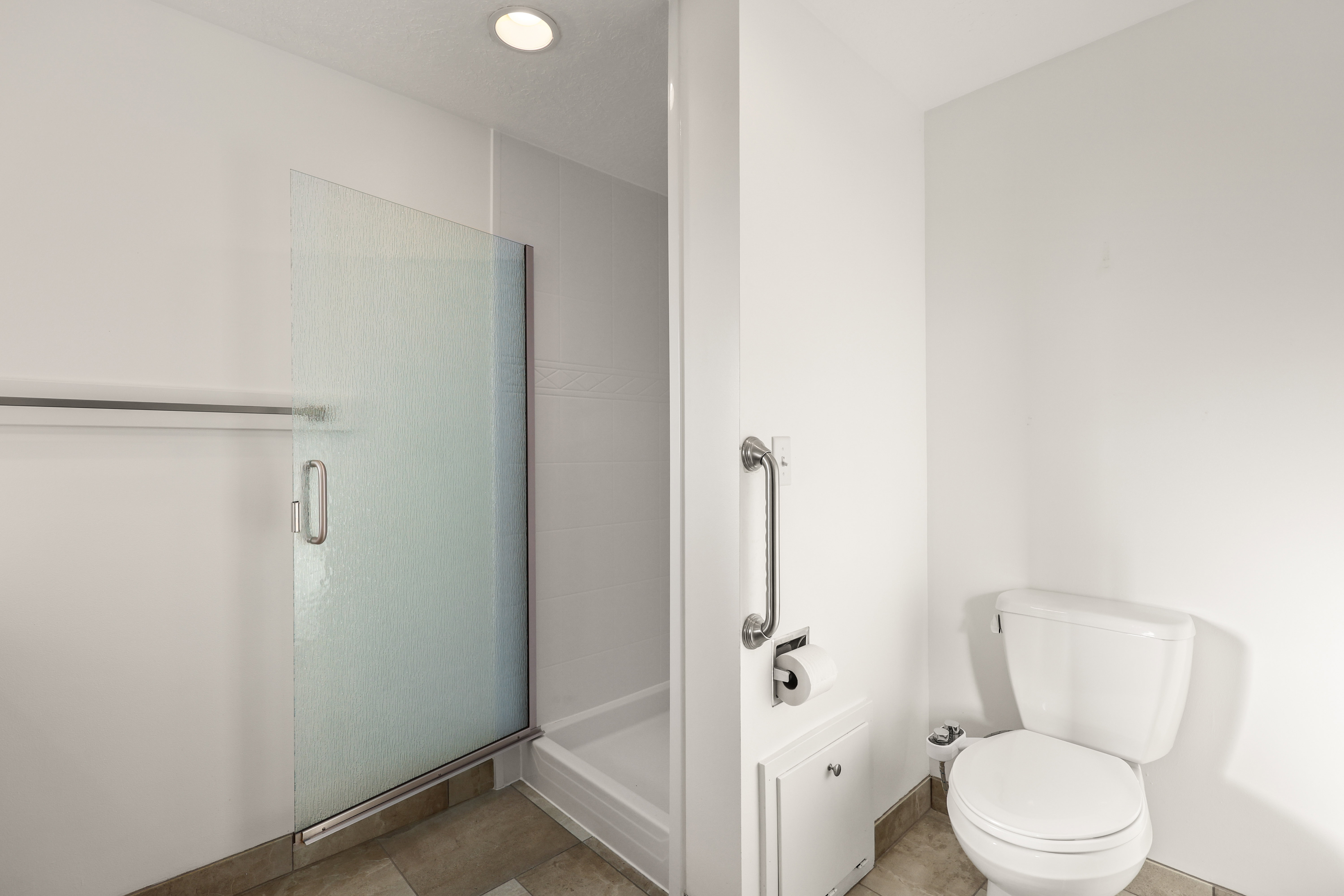 Bathroom with a shower stall and toilet