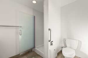 Bathroom with a shower stall and toilet