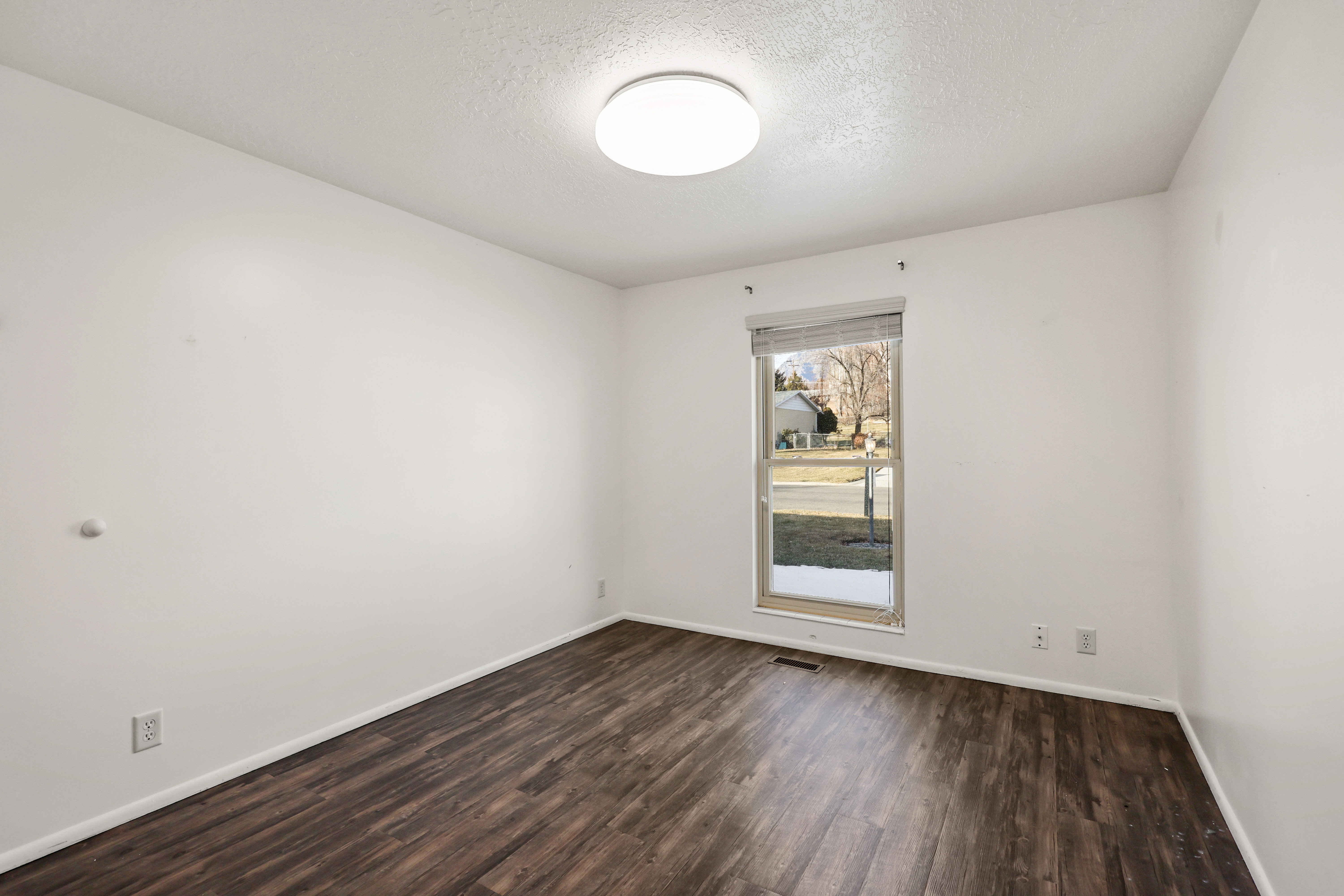 Unfurnished room with a textured ceiling and dark wood-style floors