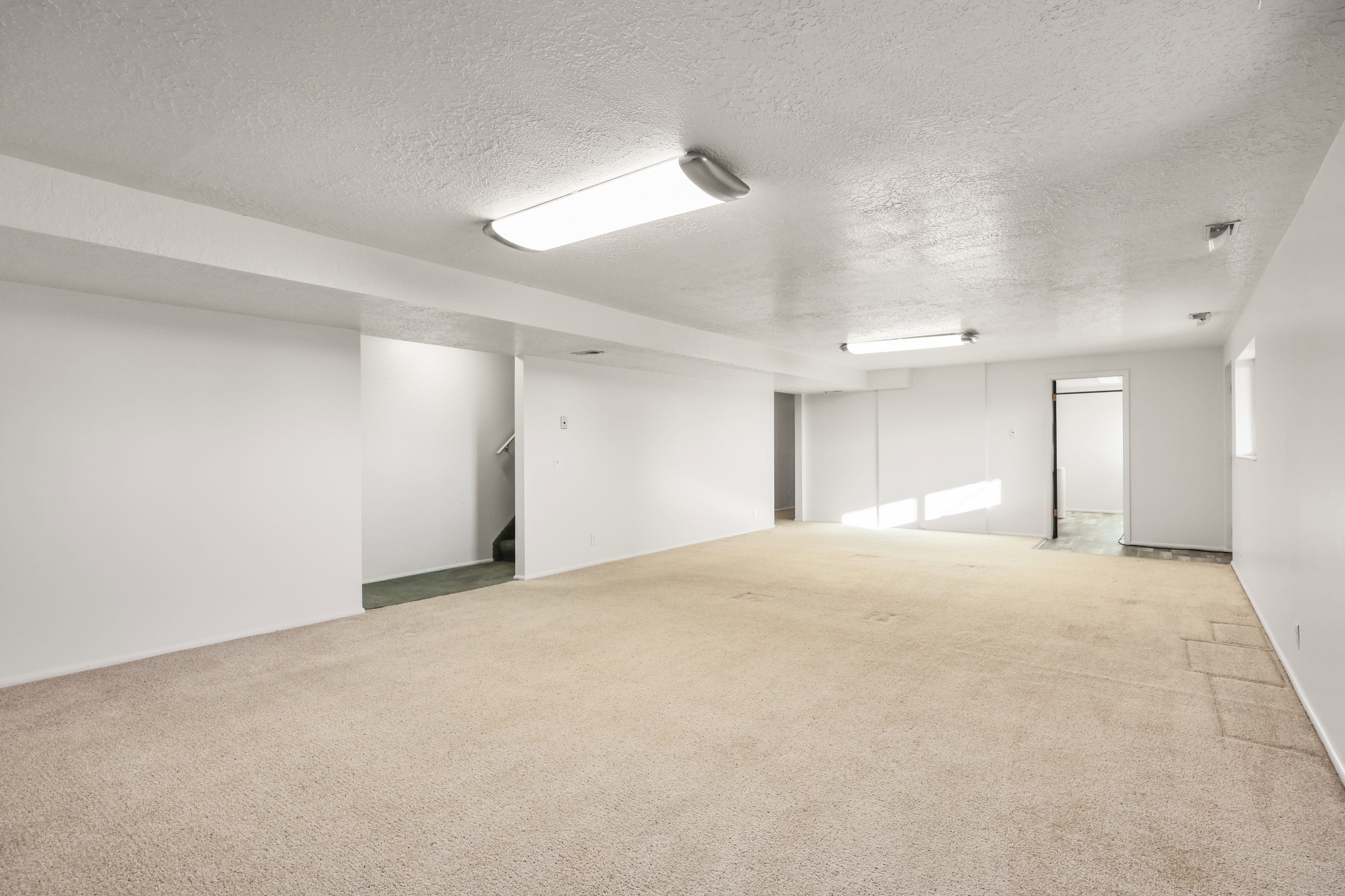 Spare room with a textured ceiling and light carpet