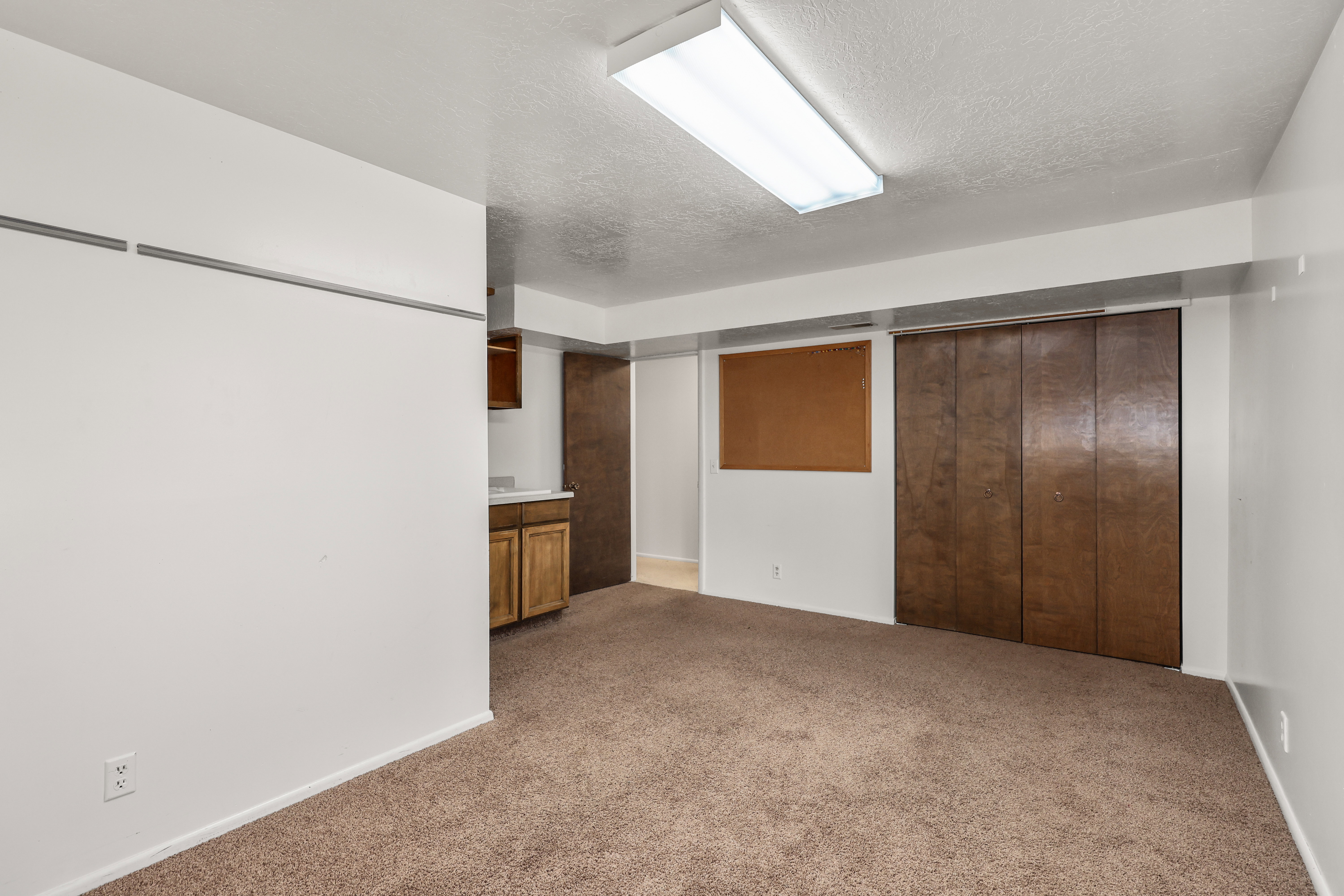 Finished below grade area with a textured ceiling and light colored carpet