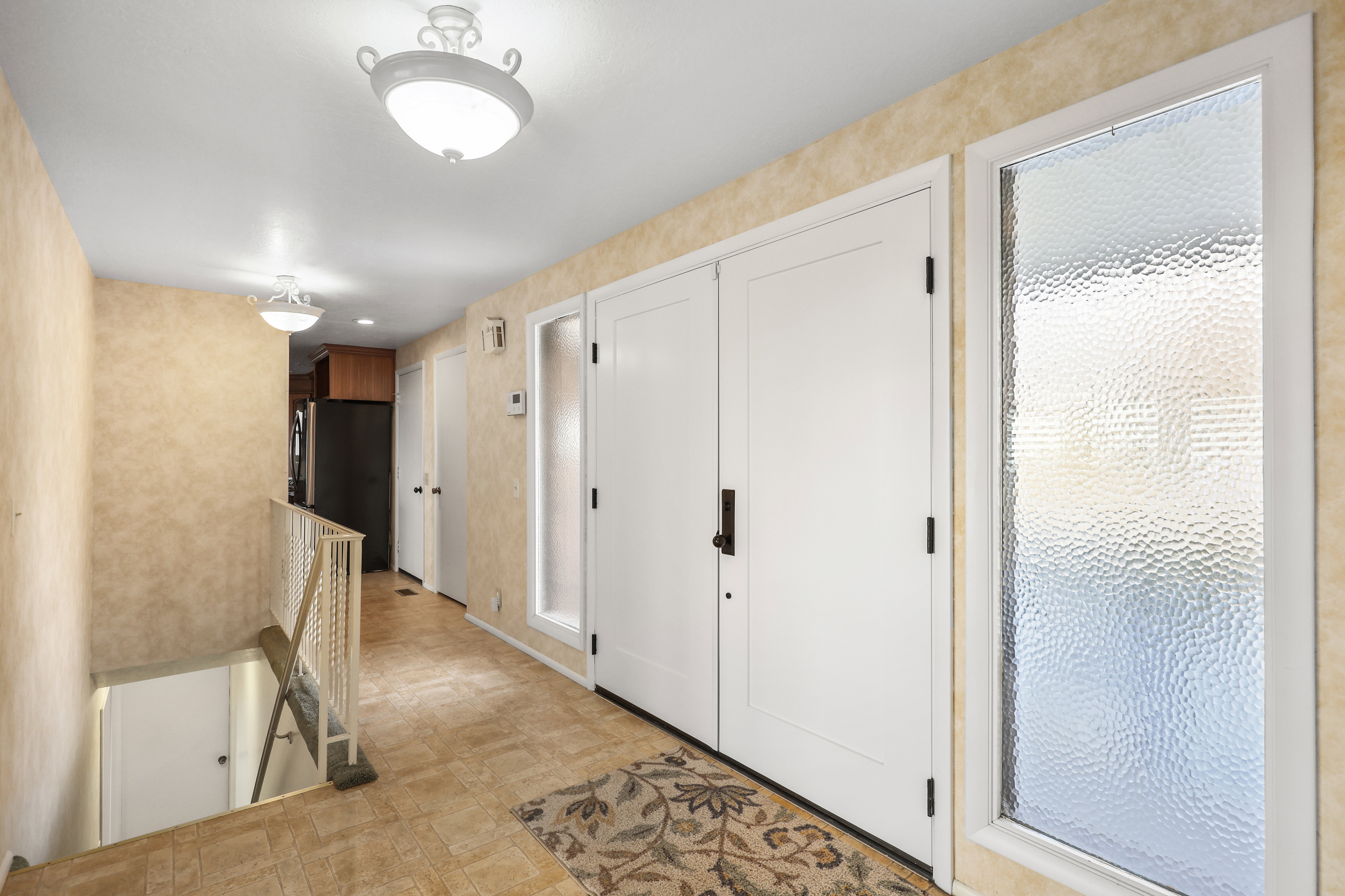 Hall featuring an upstairs landing and light floors