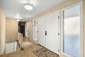 Hall featuring an upstairs landing and light floors