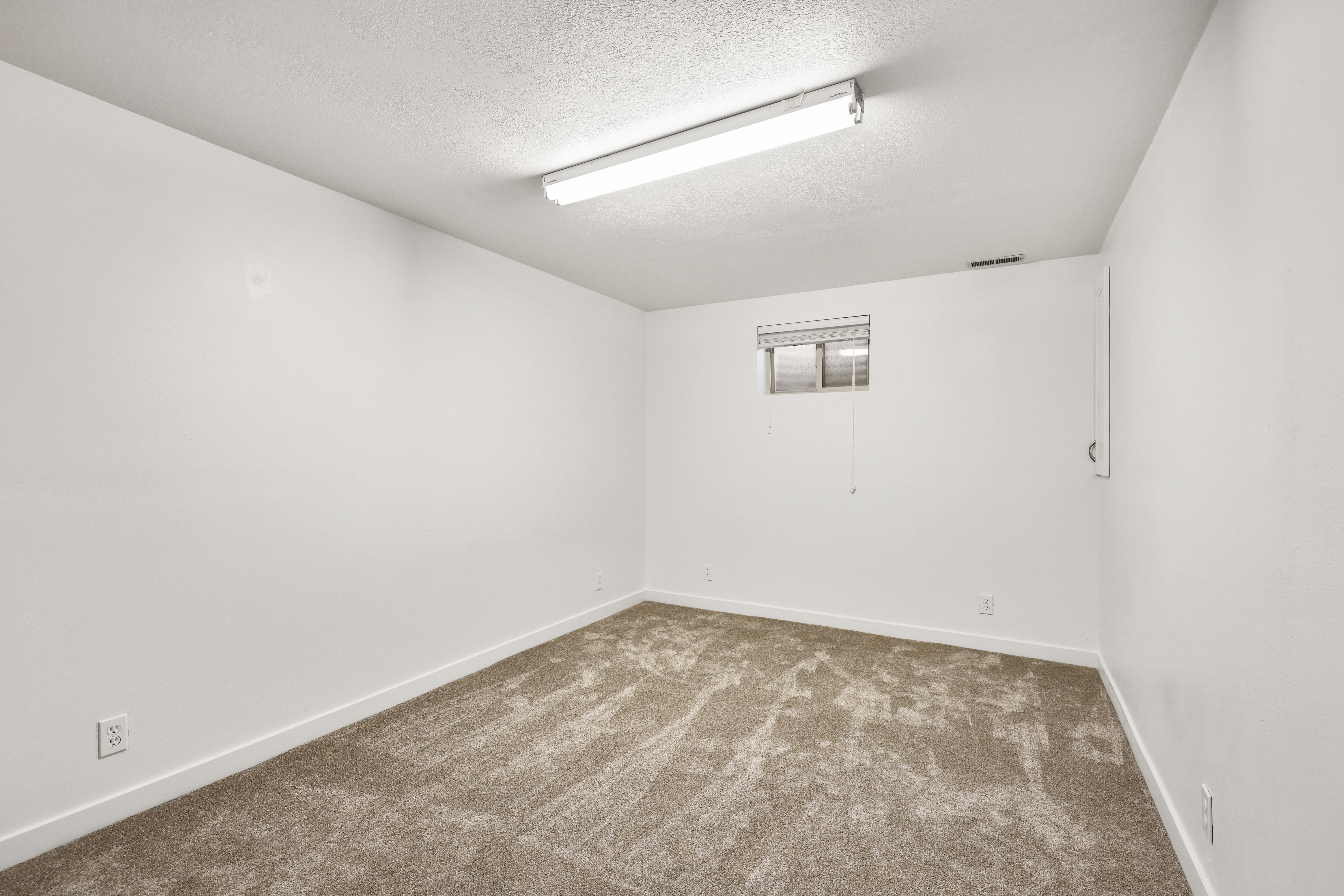 Carpeted empty room with baseboards and a textured ceiling