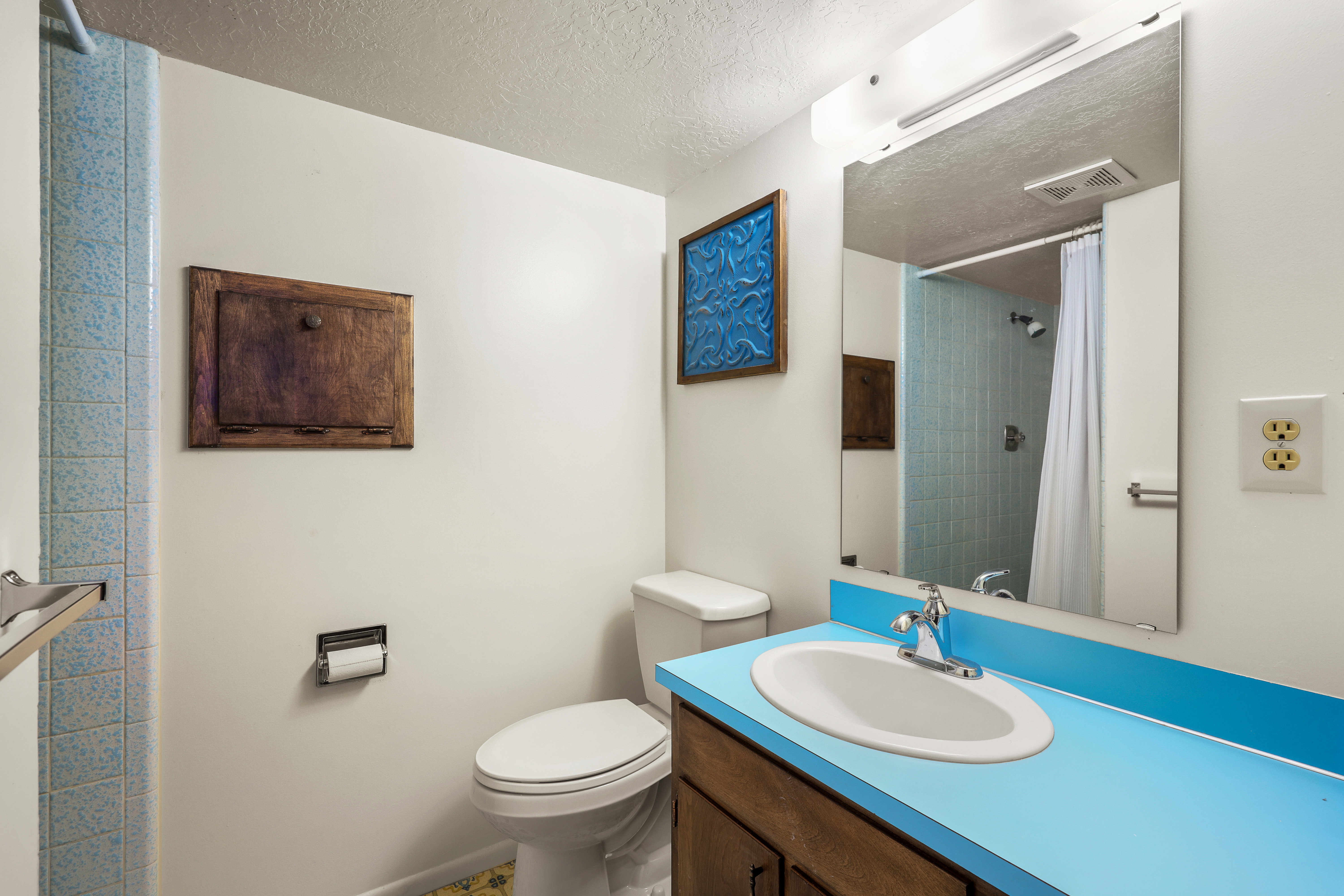 Full bathroom with a textured ceiling, vanity, and a shower with shower curtain