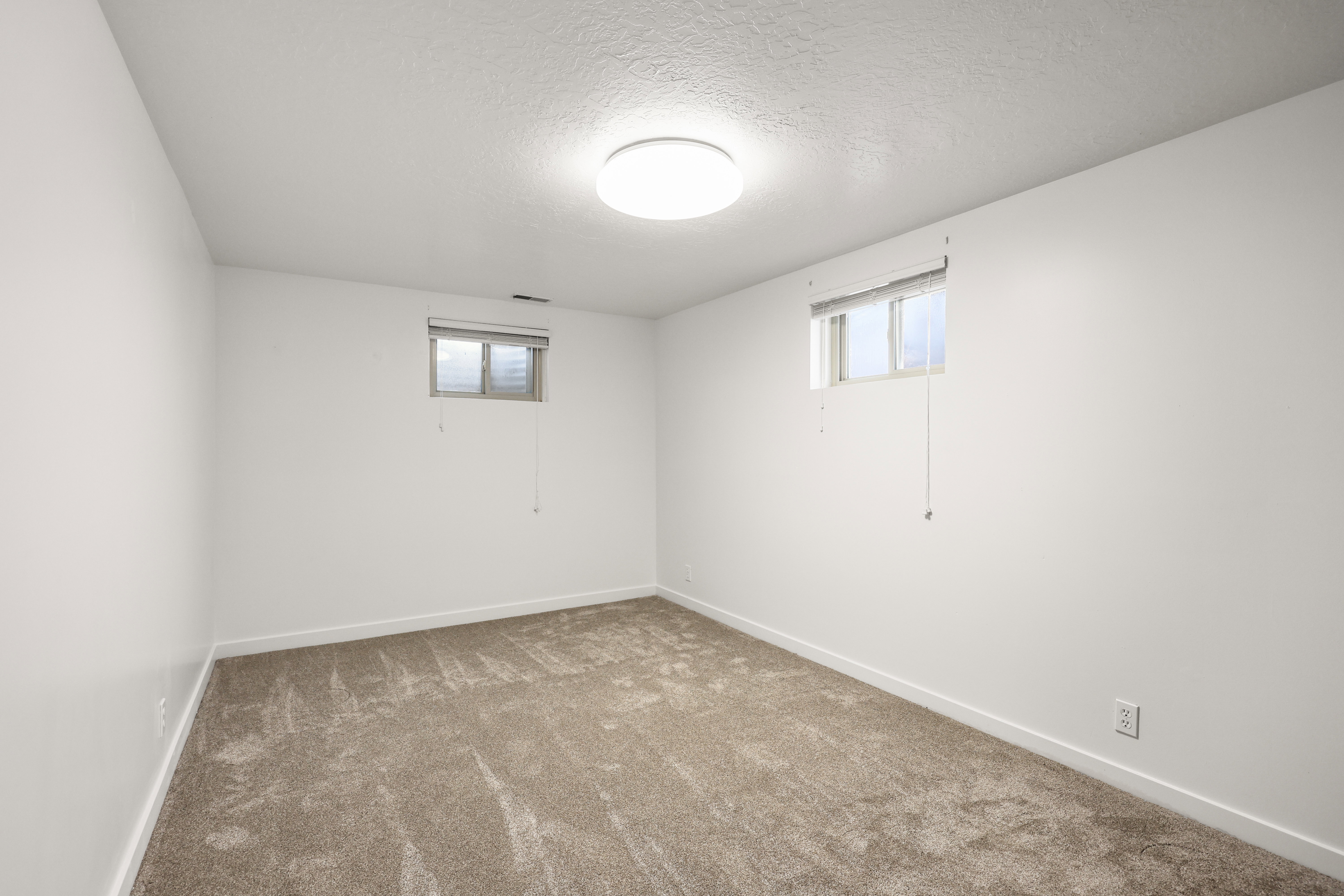 Below grade area with carpet and a textured ceiling