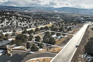 Aerial overview of property's location featuring a mountain backdrop and property boundaries highlighted