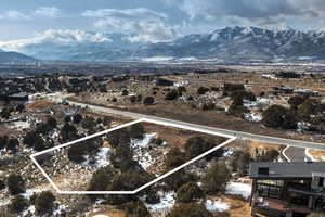 Aerial overview of property's location with a mountainous background and property parcel outlined