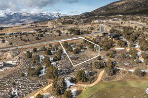 Aerial view of property's location with mountains, property parcel outlined, and rural landscape