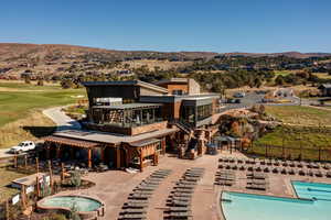 Back of property featuring a patio area, a community pool, a mountain view, and a balcony