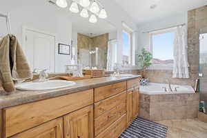 Full bath featuring a stall shower, double vanity, and a garden tub