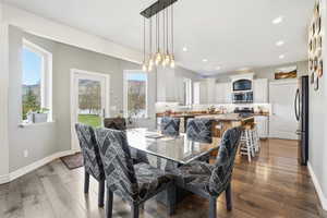 Dining area with dark wood finished floors and recessed lighting