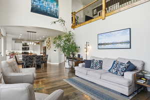 Living room with dark wood finished floors, recessed lighting, and a high ceiling