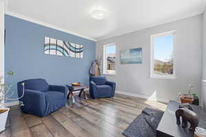 Living area with hardwood / wood-style floors and crown molding