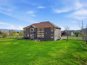 Rear view of house with a mountain view and a fenced backyard