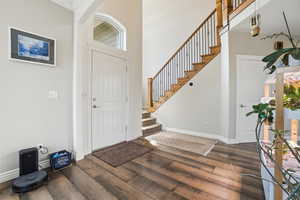 Entrance foyer featuring dark wood-type flooring and a high ceiling