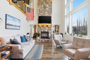 Living area featuring wood finished floors, a high ceiling, and a fireplace